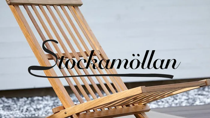 En ljusbrun lamellträ solstol med texten "Stockamöllan" överlagd.