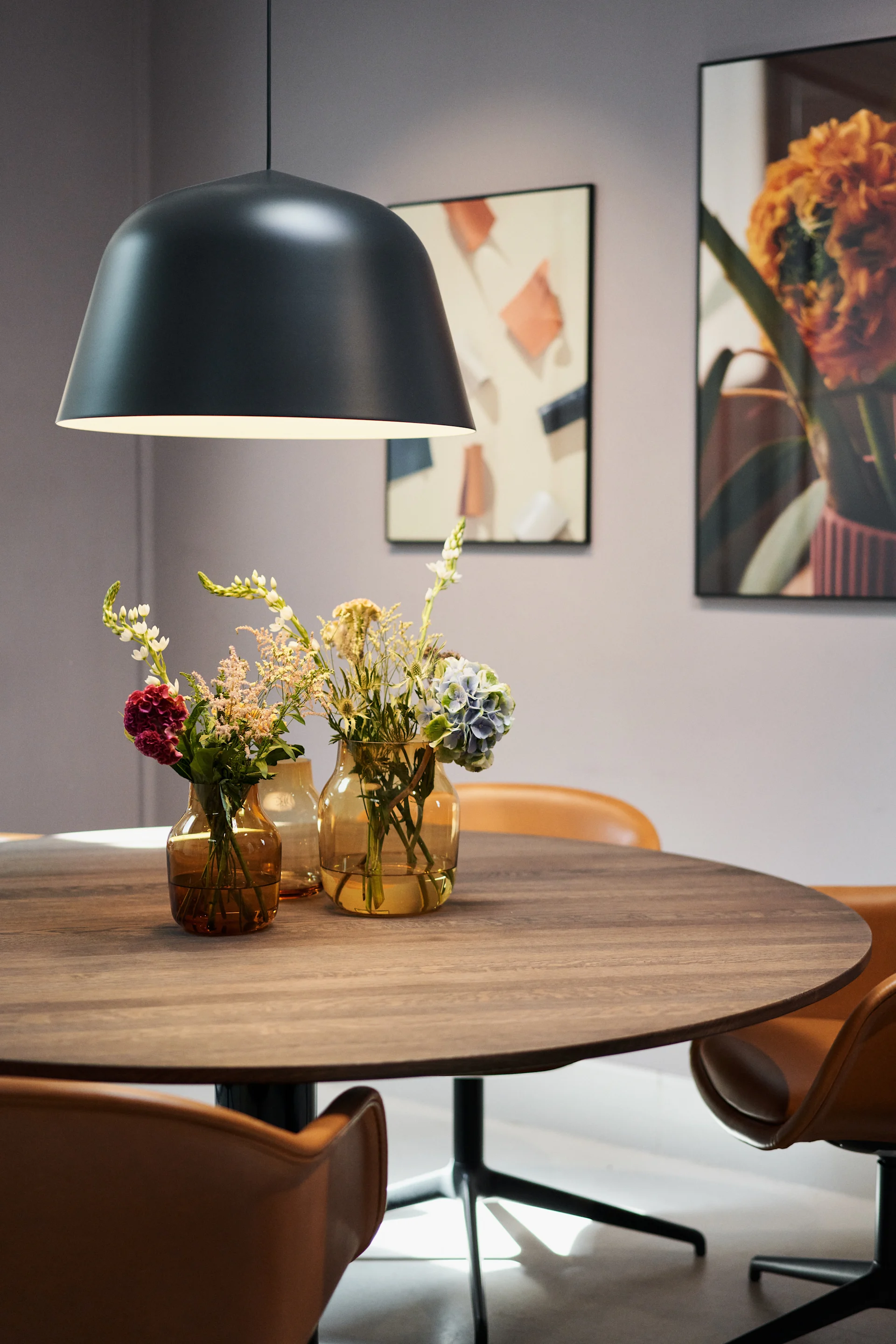 Stilgulde höstens inredning 2023, bild som visar Ambit taklampa i svart hängandes över midst bord i rökt ek, på bordet står tre Silent vaser i färgen burnt orange med blommor i.