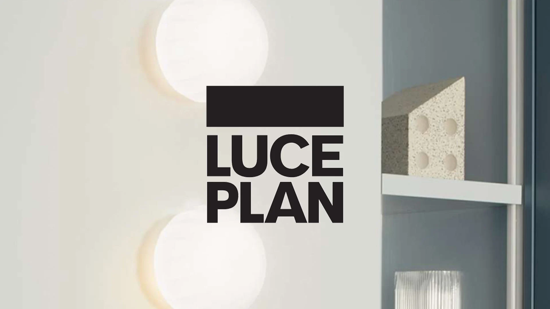 Två runda, lysande vägglampor och "LUCE PLAN" logotyp. Hylla till höger med spräcklig, geometrisk dekor och räfflat glasobjekt.